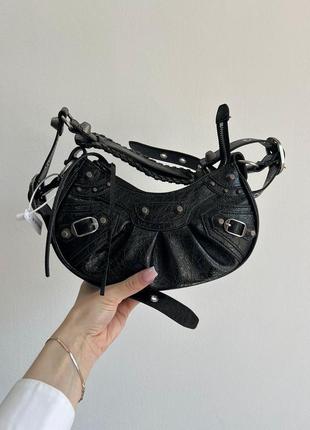 Сумка balenciaga из лакированной текстурной кожи имеет металлические пены.