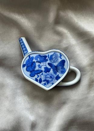 Декоративный чайник-лейка в виде сердечка. имеет изображение цветов и бабочек.