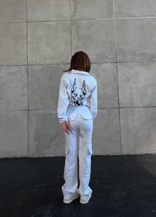 Джинсовый костюм с укороченной ветровкой с принтом накатом добермана на спине с брюками карго с боковыми накладными карманами