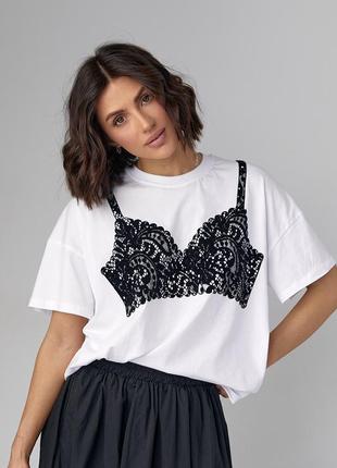 Женская футболка oversize украшена принтом в виде кружевного лифа.