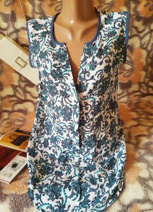 Распродажа оригинальная удлиненная женская блуза топ майка без рукавов,
в цветочный принт. 
цвет белый с синими цветами. 
состояние отличное, без дефектов.