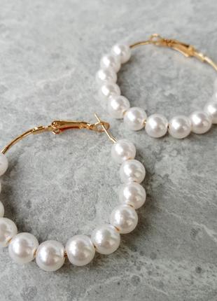 Ніжні сережки кільця з перлами в золотистому кольорі.