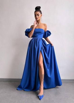 Синя сукня з розрізом на спідниці та об'ємними рукавами
