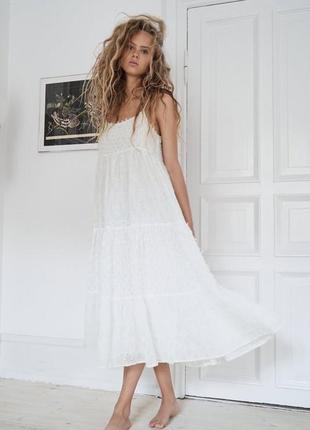 Стильна біла ярусна сукня-сарафан на тонких бретелях зі вставками прошвою і фактурними китицями