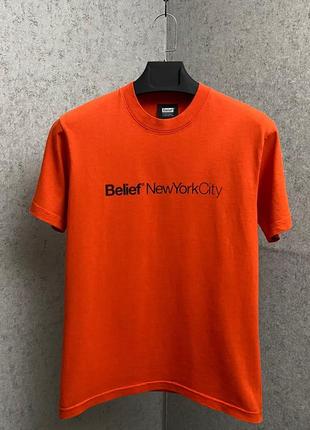 Оранжевая футболка от бренда belief
