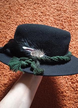 Чорний капелюх з фетра з пір'ям.