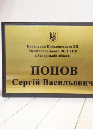 Металлическая табличка на деревянной основе