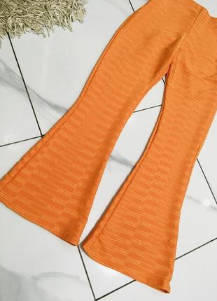 Яркие оранжевые леггинсы клёш с текстурой м3 фото