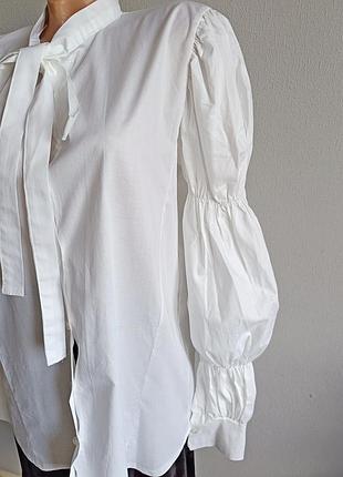 Біла блуза з об'ємними рукавами, та коміром аскот.