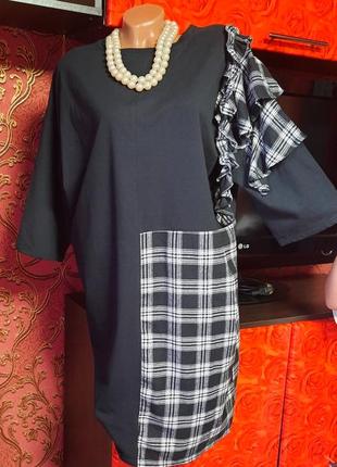 Черное платье с клетчатыми вставками.