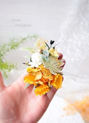 Заколка з квітами в жовтому кольорі.