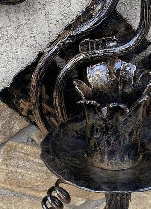 Ковані бра ручної роботи на фоні медивної лампи