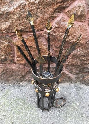 Кованый средневековый бра ручной работы на фоне средневекового фонаря (факела)