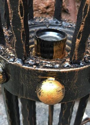 Кованый средневековый бра ручной работы на фоне средневекового фонаря (факела)