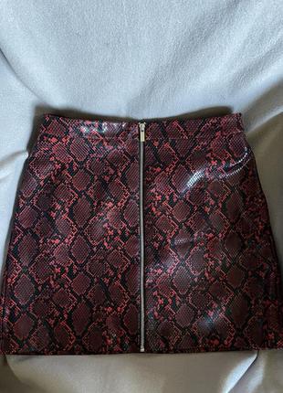 Короткая темно-красная типа кожаная юбка со змеиным принтом