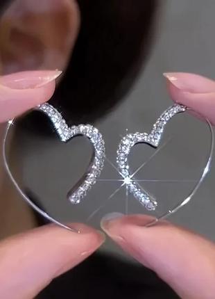 Сріблясті сережки у вигляді сердечок з камінцями