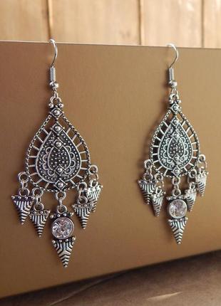 Сріблясті великі сережки в античному стилі.
