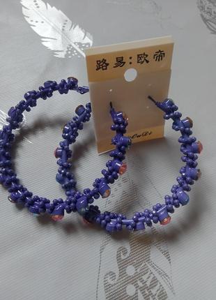 Ефектні сережки-кільця фіолетового кольору з кольоровими стразами1 фото