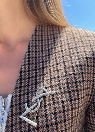 Брошка з логотипом сріблястого кольору