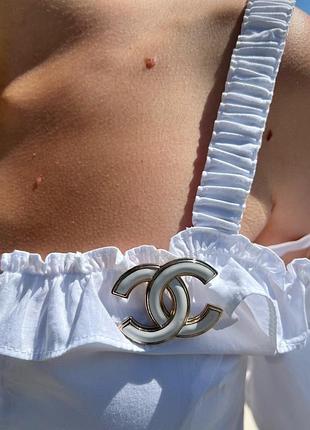 Брендова брошка в білому кольорі з позолотою