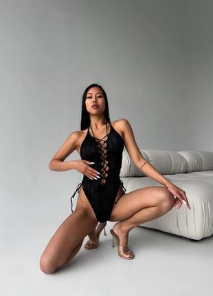 Жіночий чорний суцільний купальник з фактурної тканини на завʼязках2 фото