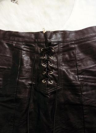 Черная кожаная короткая мини юбка с люверсами шнуровкой завязками спереди4 фото