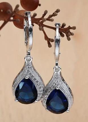 Сережки сріблястого кольору з синіми камінцями