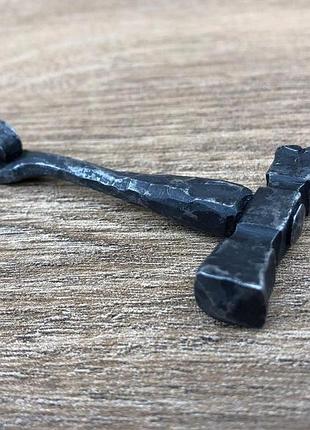 Маленький подвесной молоток изготовлен из мягкой стали