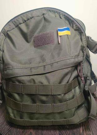 Значок-брошка у формі стяга україни, що майорить.