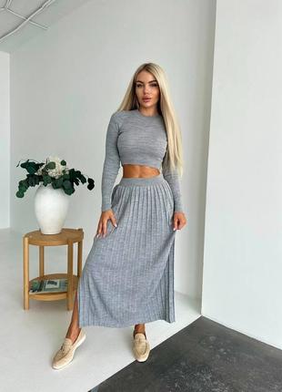 Трикотажный костюм представлен с плиссированной юбкой максы и укороченным лонгсливом