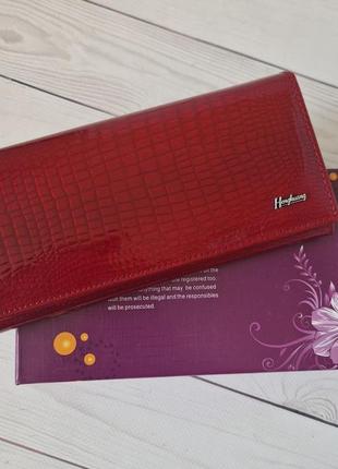 Красный кожаный кошелек на кнопке