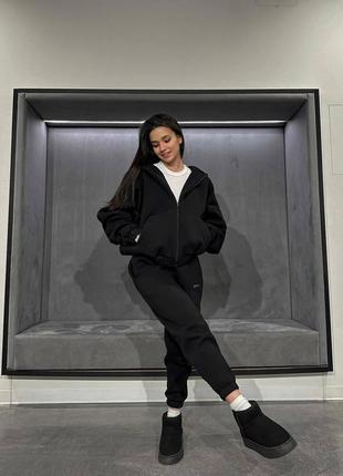 Женский спортивный костюм черный кофта на замке штаны снизу на манжетах с маленькой надписью на кофте и штанах