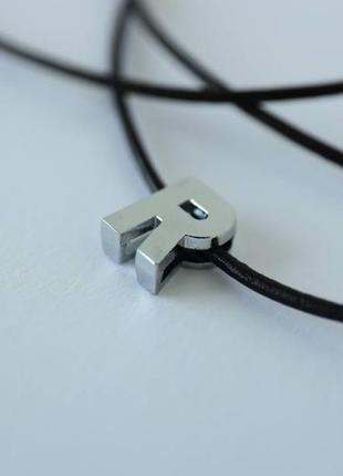 Літера в кольорі срібло на шкіряної мотузочці