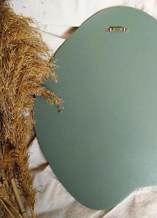 Интерьерное зеркало неправильной формы в деревянной раме шалфейного цвета, овальное зеркало