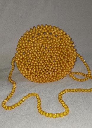 Жіноча кругла сумочка з намистин жовта з довгим ремінцем на магнітній застібці