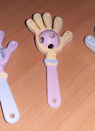 Игрушка пластиковая ладошка с шариком в середине.
