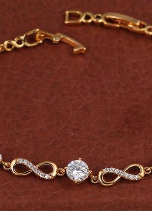 Браслет xuping jewelry восьмерки с тремя белыми камнями по центру 21 см 7 мм золотистый