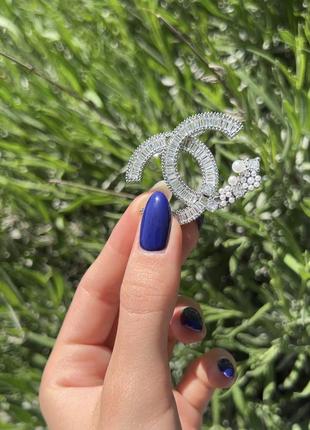 Брендовая брошь серебряного цвета с камнями