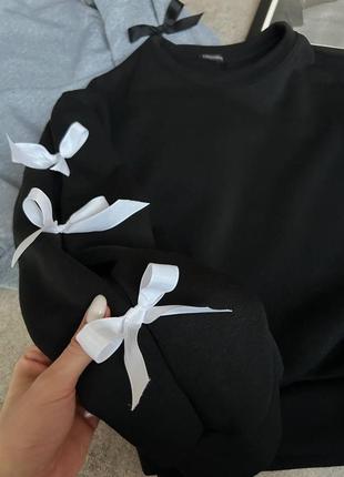 Трендовый свитшот с бантиками на рукавах.