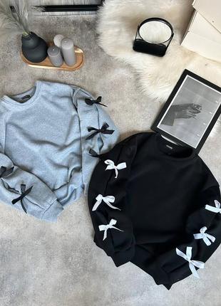 Трендовый свитшот с бантиками на рукавах.