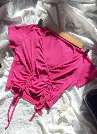 Розовый топ-футболка с v-образным вырезом и затяжками.