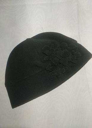 Шапка однослойная,флисовая черного цвета, декорированная аппликациями цветочками.