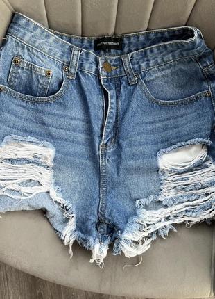 Асимметричные синие джинсовые шорты порваны с рваностями с высокой посадкой
