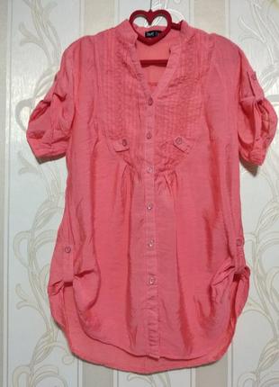 Тоненька блуза коралового кольору.