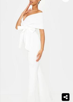 Белый комбинезон с открытыми плечами и расклешонными штанами7 фото