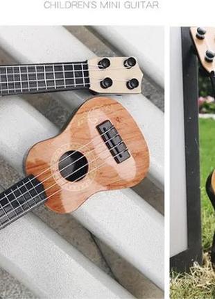 Гітара дитяча іграшка, коричнева, дитяча укулеле, довжина - 25см, ширина 9см, пластик, 4 струни, унісекс, 3+5 фото
