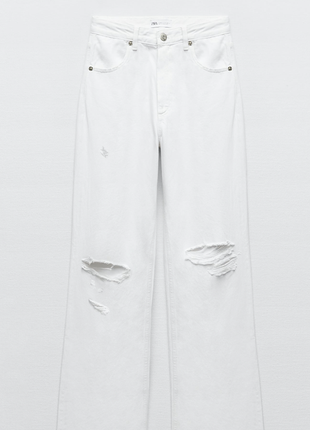 Білі джинси прямого крою з протертостями і необробленим краєм.