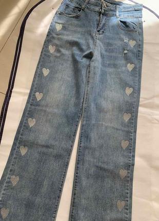 Джинсы женские шикарного качества, мягкий джинс, декорированные сердечками из страз1 фото