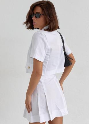 Костюм жіночий літній зі спідницею пліссе та коротким жакетом білого кольору.2 фото