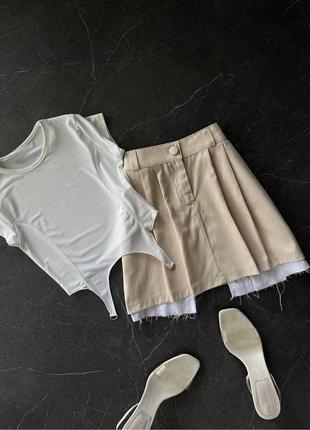 Трендовая бежевая короткая мини-юбка со вставками лето 20231 фото